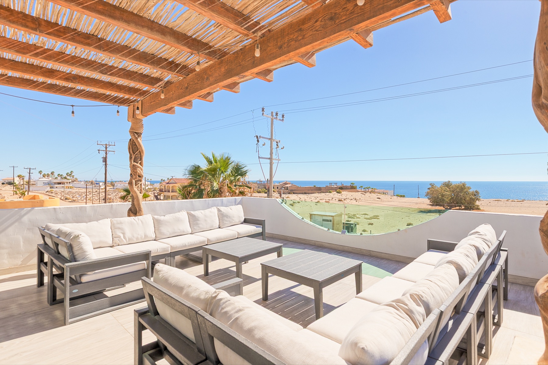 Upper terrace with cushioned lounge seating and ocean view