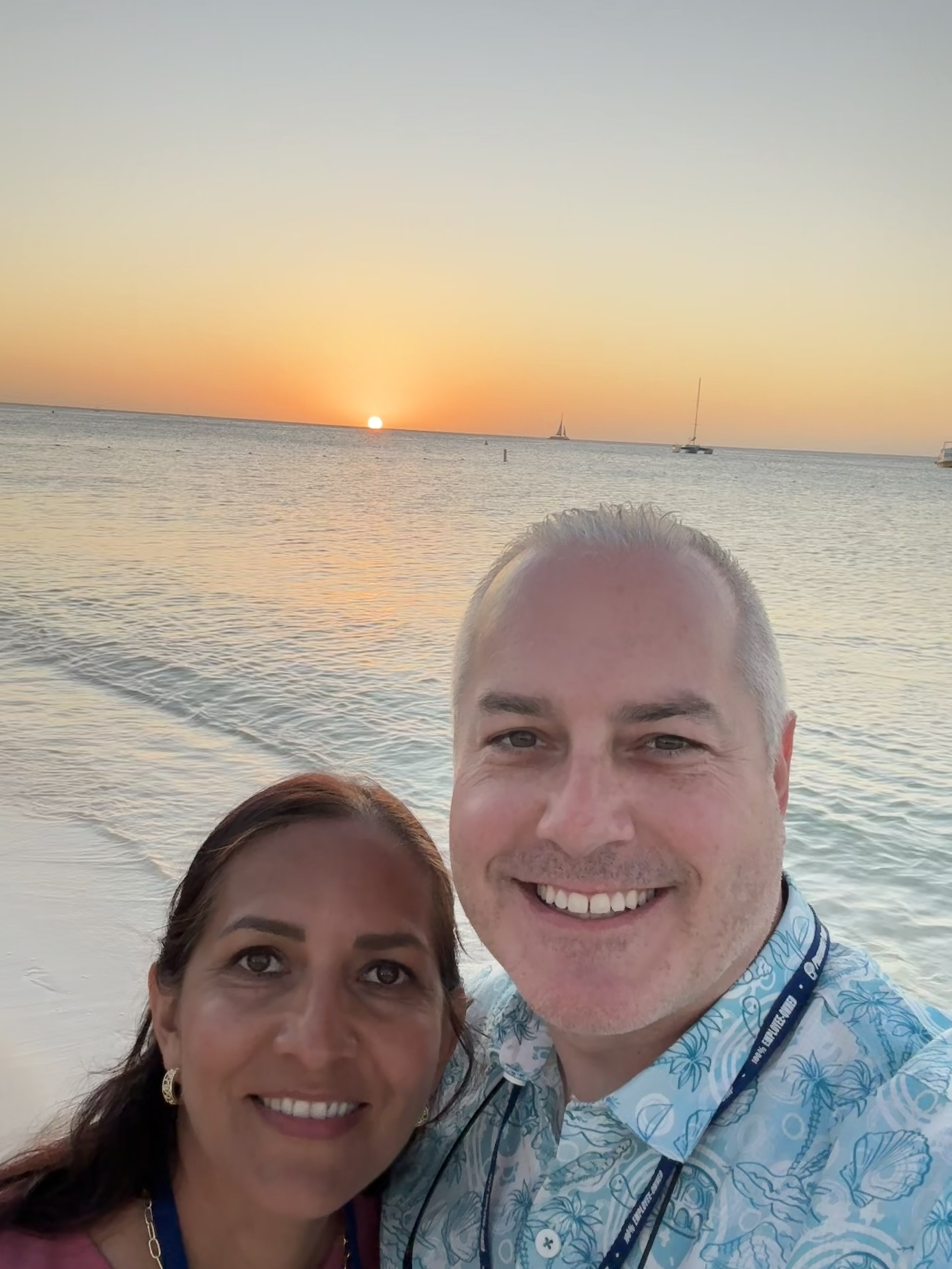 Jared and another person by the water at sunset