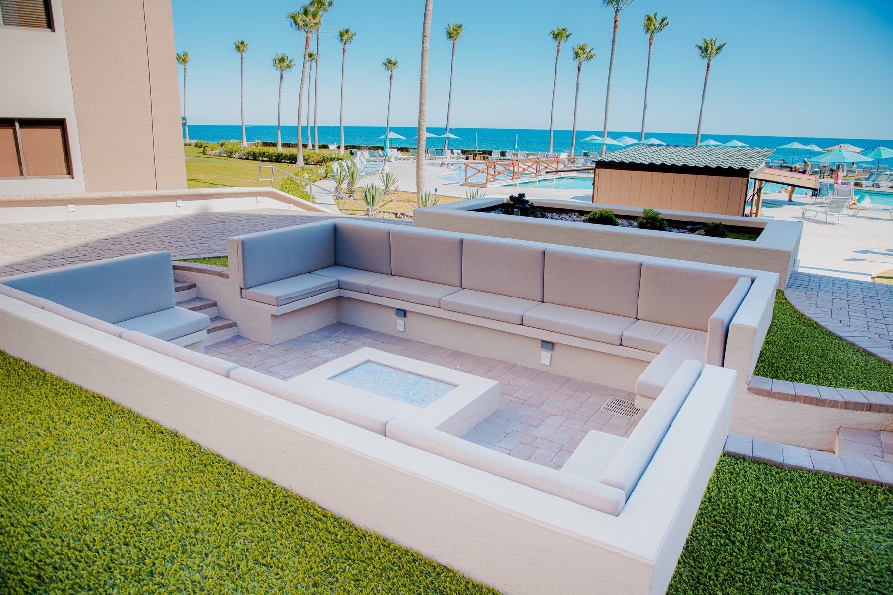 Outdoor lounge seating beside the resort pool and beach